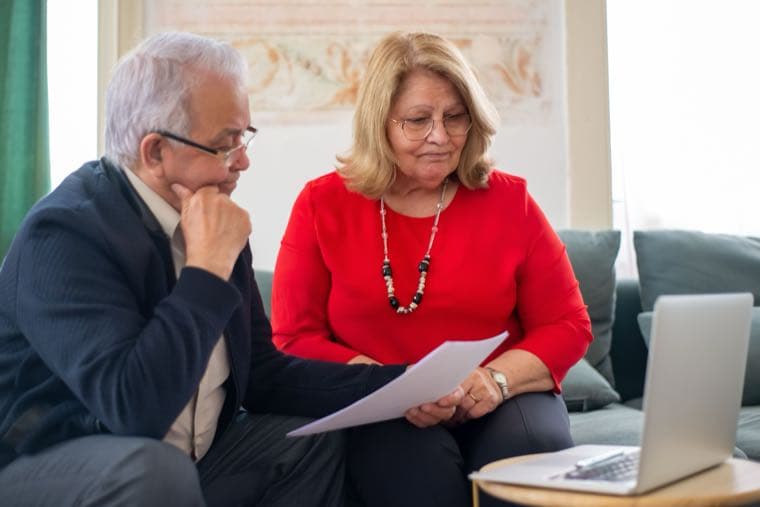 An older couple reviewing financial documents together at home