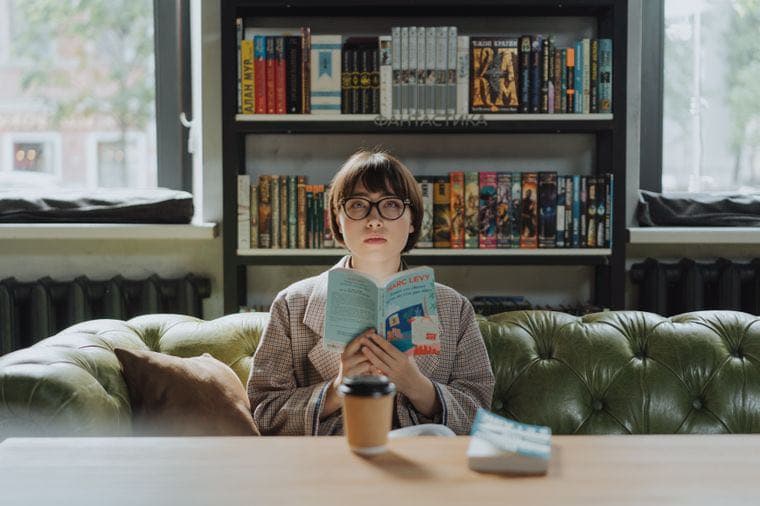 A person reading a book in a cosy library cafe