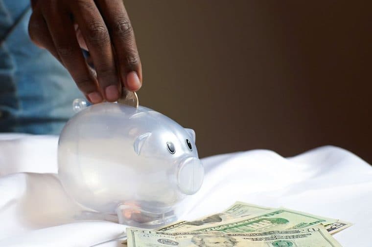 A child putting a coin into a money box