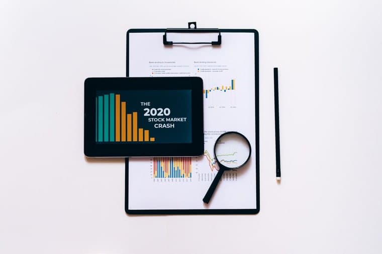 Analysing shares with charts and a magnifying glass, representing blue chip investing