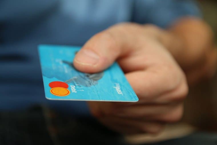 A business debit card and laptop, representing a small business bank account