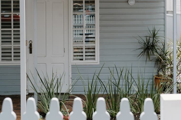 A classic Australian weatherboard home with a white picket fence