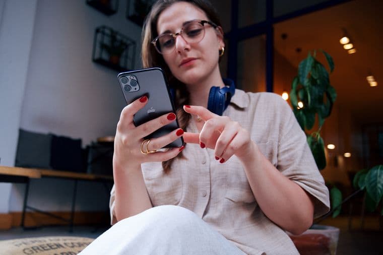 A young woman checking her phone in a cafe, seen from a low angle