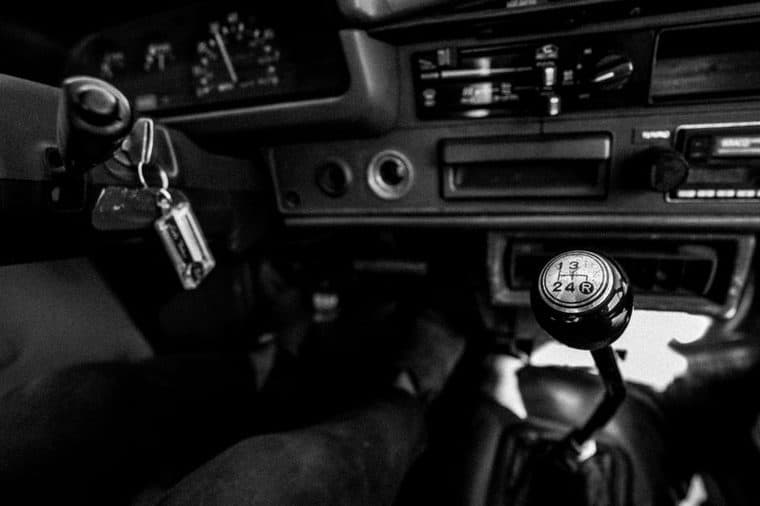 A person holding car keys next to a car