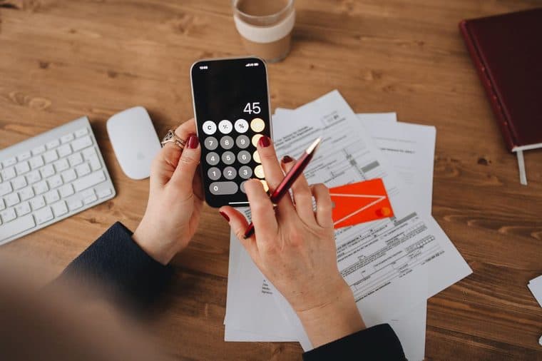 A person working out bills on a calculator at a desk