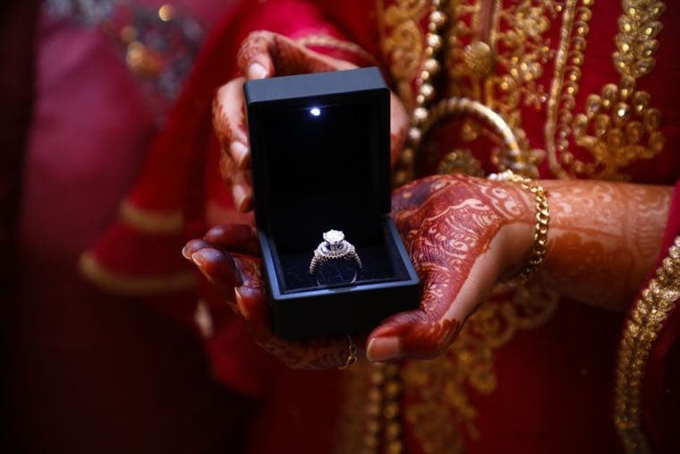 A diamond engagement ring resting in an open ring box