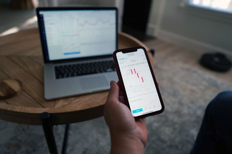 Investor comparing ETFs and managed funds on a phone and laptop