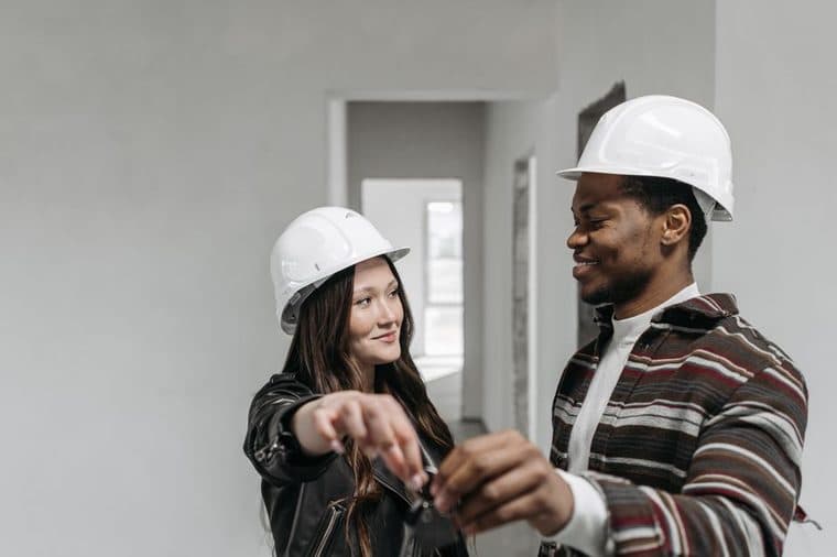 A young couple holding the keys to their first new home in NSW