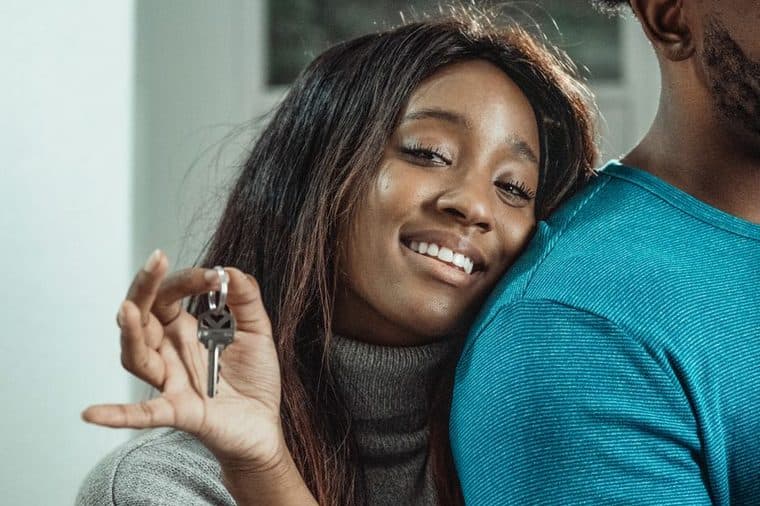 A young couple holding the keys to their first new home in Victoria