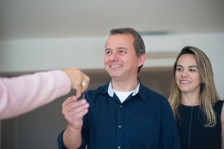 A young couple holding the keys to their first new home in Western Australia