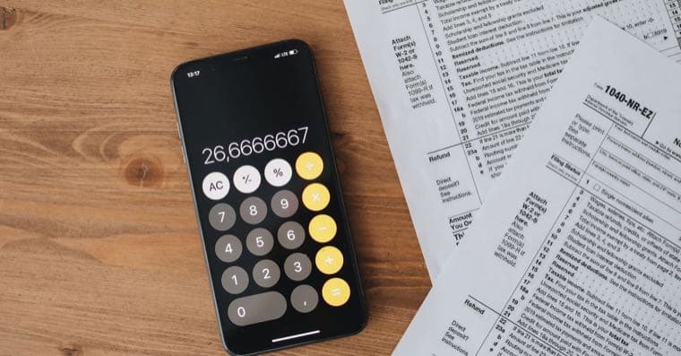 An Australian tax return, calculator and ETF statements on a desk, representing how ETFs are taxed.