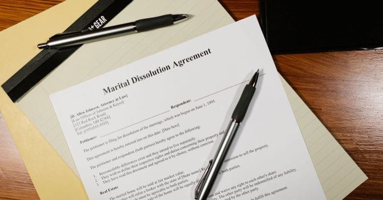 A person reviewing legal estate documents at a desk with a pen