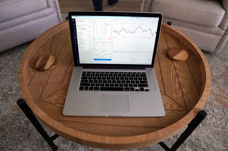 A laptop showing an investment trading platform on a table