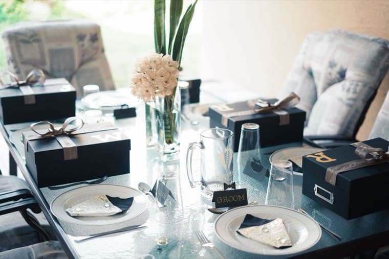 A wedding reception table set with elegant gift boxes