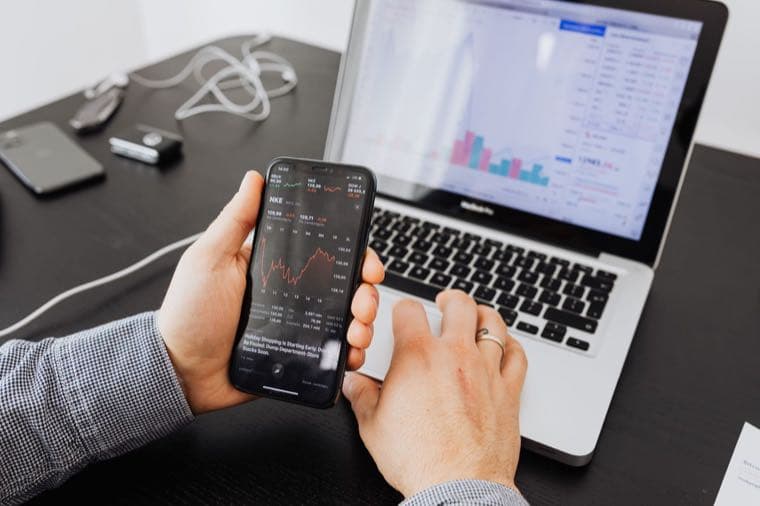 A person selling shares on a stock trading app on their phone