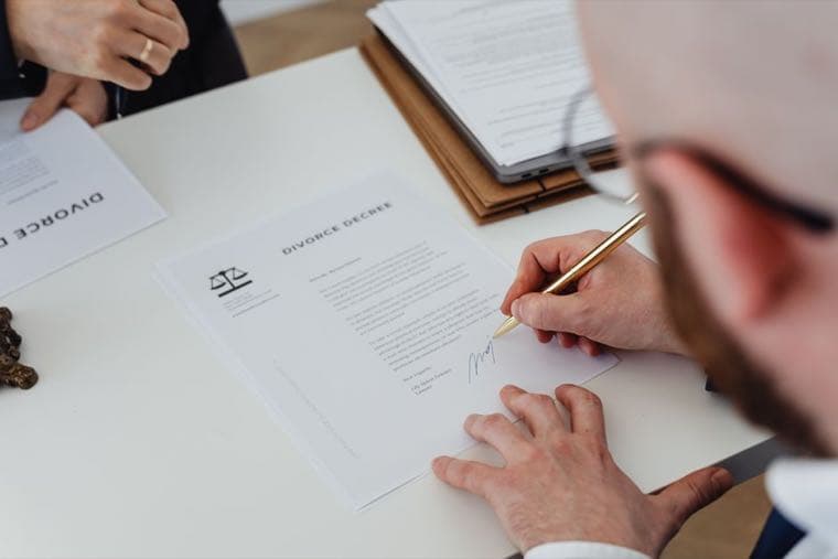 A couple signing legal documents at a desk