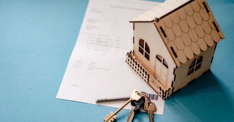 A set of house keys resting on a property title document