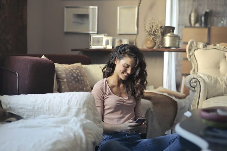 A person smiling while looking at their smartphone