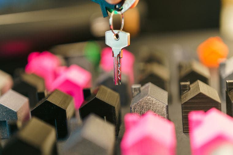 A key hanging over a group of small model houses