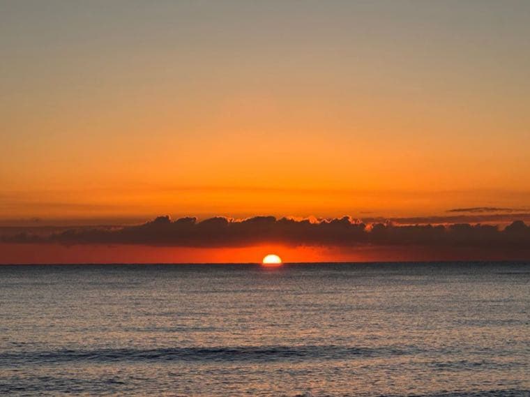 A quiet sunrise over calm water, evoking relief and a fresh start with money stress