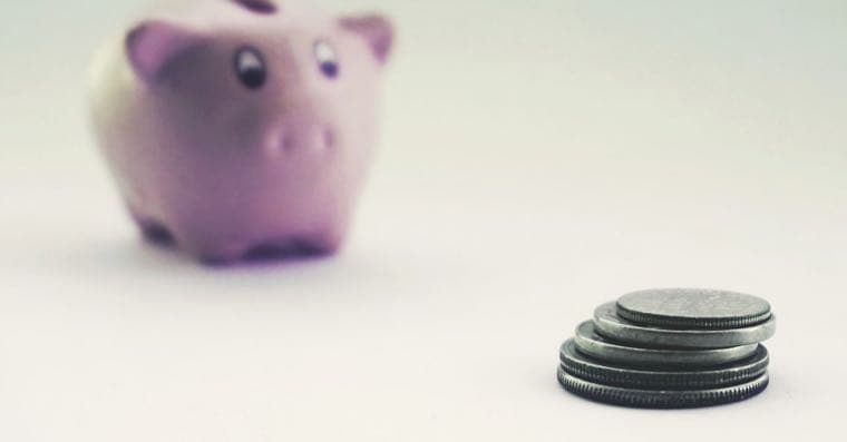 Coins stacked beside a piggy bank
