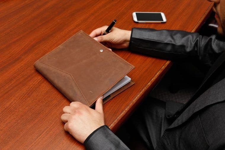 A person at a desk calmly writing out a list, representing facing debts one by one
