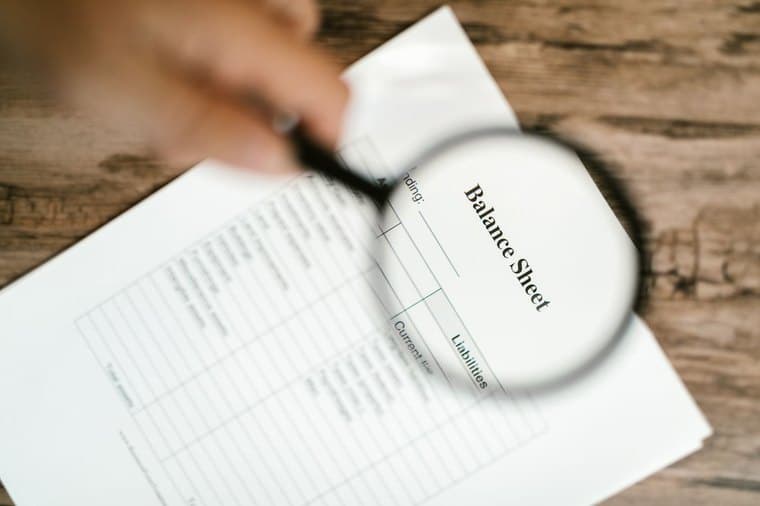 A balance sheet examined under a magnifying glass