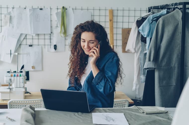 A small business owner working on a laptop in her studio