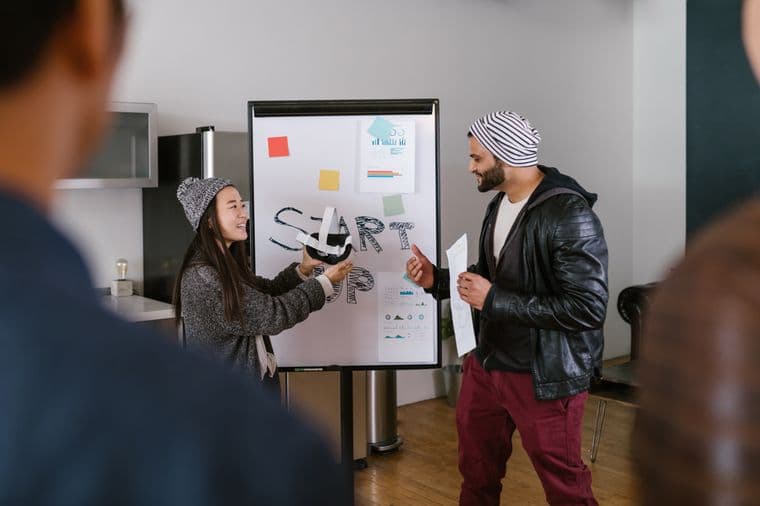 A small team brainstorming around a whiteboard in a startup office