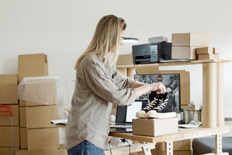 A small online business owner packing an order at home