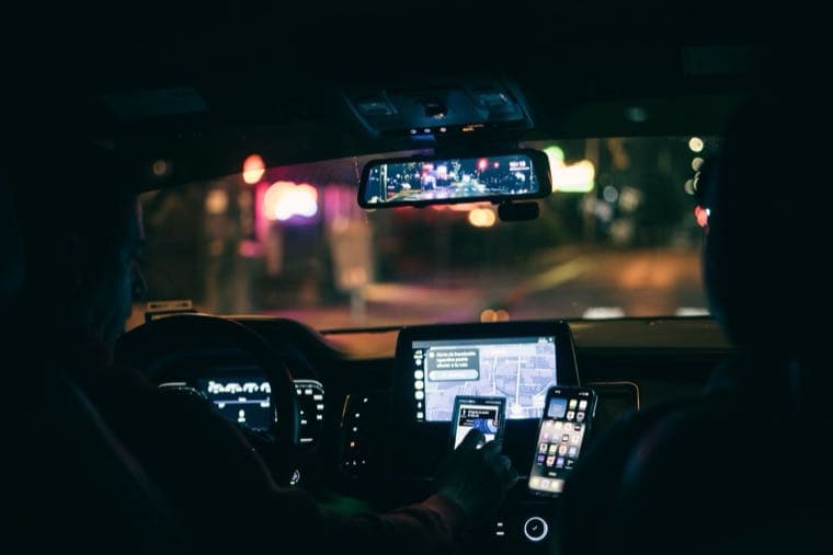 A rideshare driver using phone navigation in a car, representing Uber driver tax in Australia