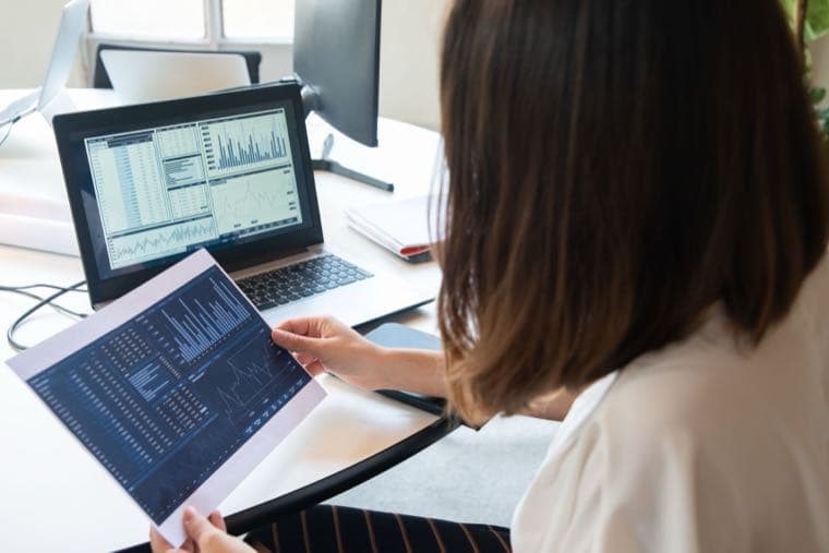 A person reviewing their annual superannuation statement at a desk with a laptop