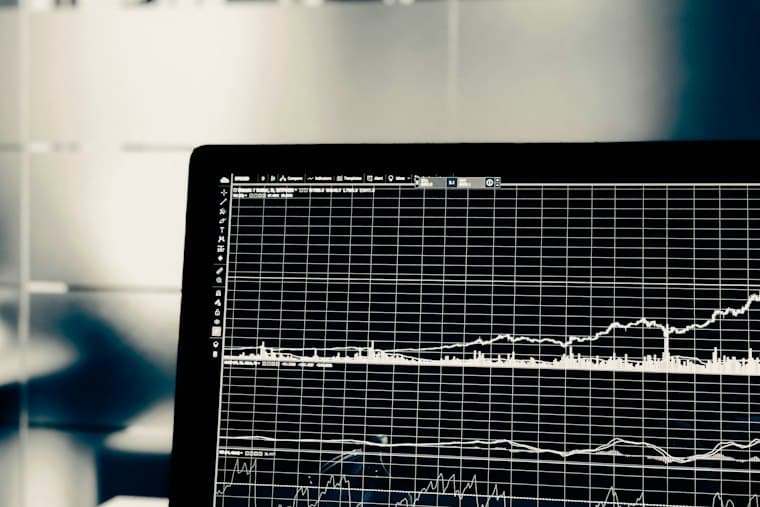 A laptop screen showing a price chart on a dark trading platform