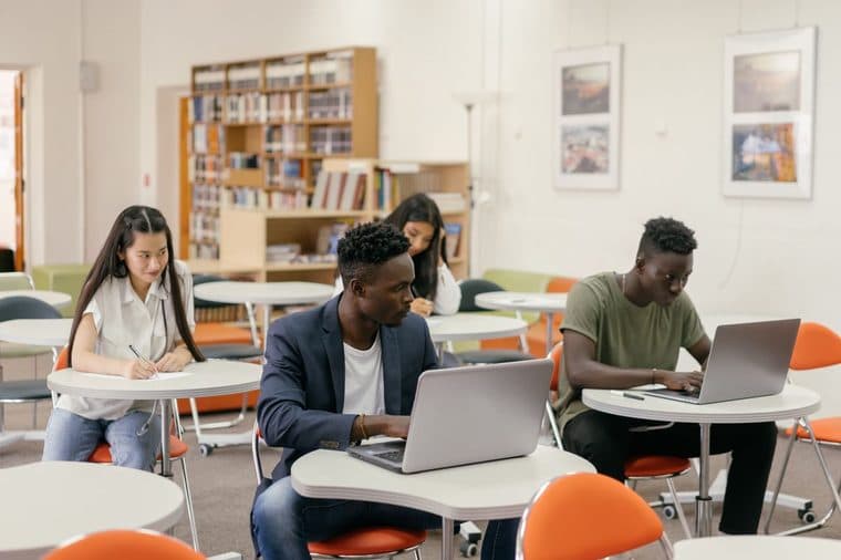 University students studying with laptops in a library