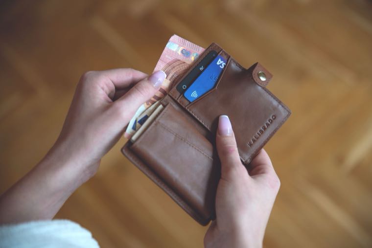 A wallet with cash and a bank card, representing debit vs credit cards in Australia