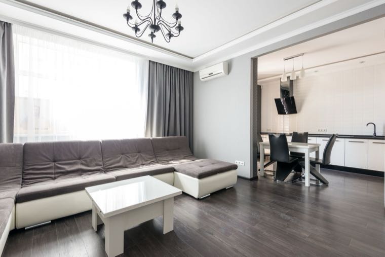 A renter cleaning a bright living room before the final inspection to get their bond back