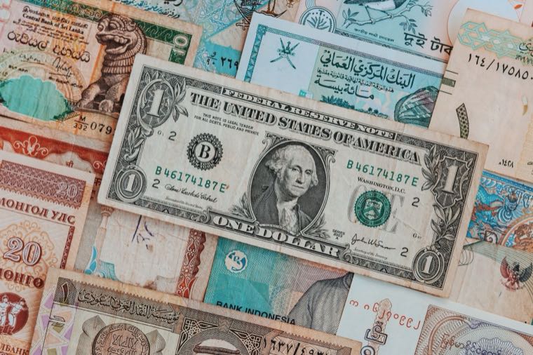 Global currencies and share charts, representing hedged and unhedged international ETFs