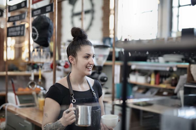 A smiling barista at work, representing minimum wage and award pay in Australia