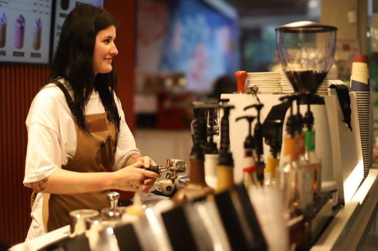 A barista working a second job in a cafe in Australia