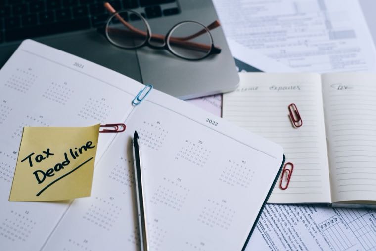 A desk calendar with a tax deadline reminder note