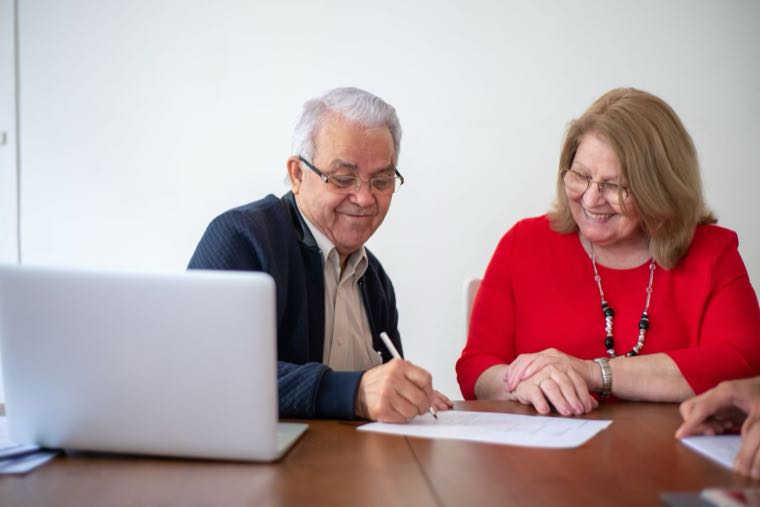 An older Australian couple reviewing self-managed super fund documents at a desk