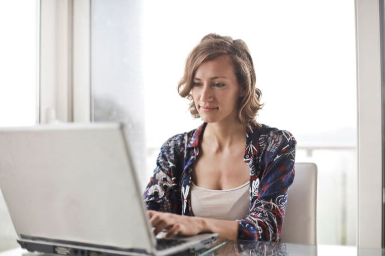 A person working from home at a laptop in a bright home office in Australia